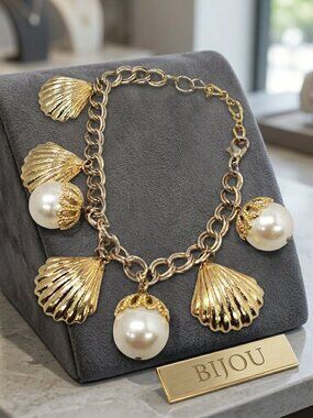 Bijou charm bracelet features faux pearls and polished gold seashell dangle NWT
